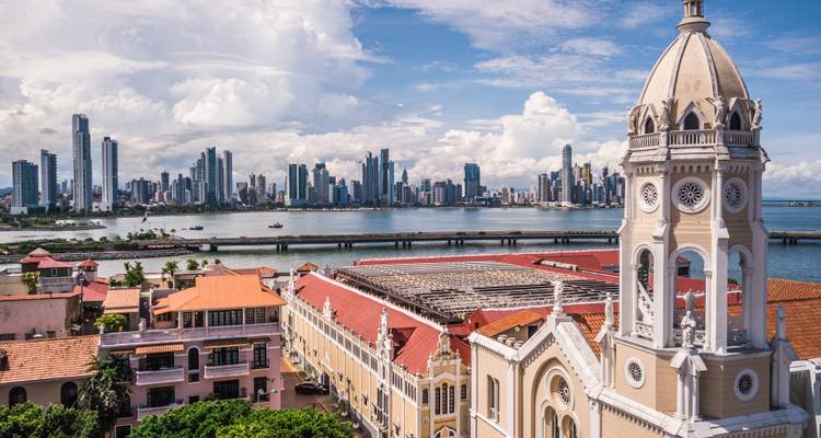 Skyline einer modernen Stadt mit hohen Gebäuden und einem historischen Vordergrund.