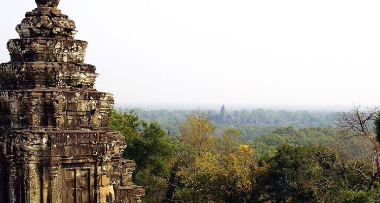 View over a forest from a temple tower under a clear sky.