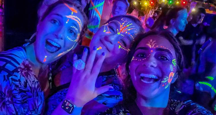 Femmes avec de la peinture de visage néon à une fête.