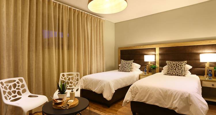 Twin bedroom with modern decor and ambient lighting.