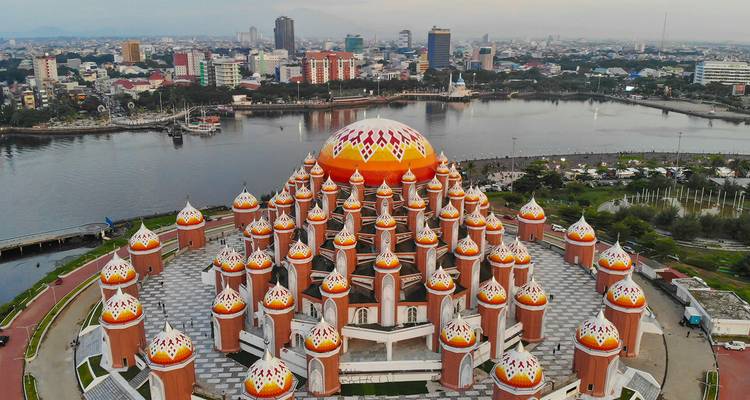 La Mosquée aux 99 Dômes à Makassar avec le paysage urbain en arrière-plan.