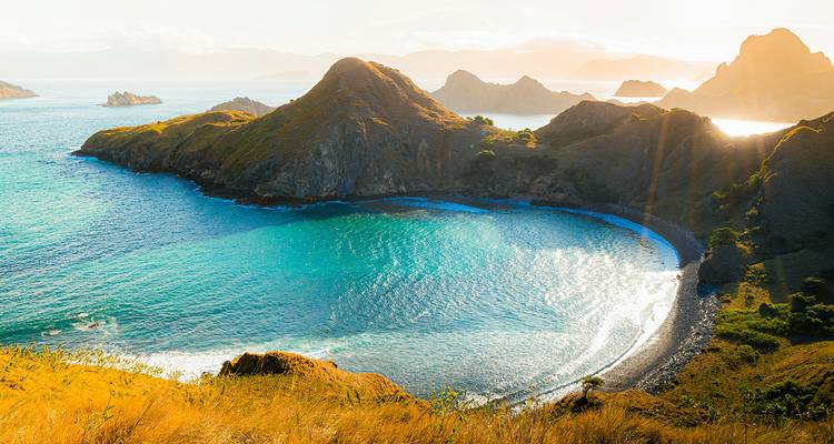 Littoral pittoresque avec des eaux turquoise et des collines ondulantes.