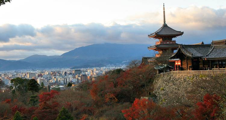 A temple overlooking a cityscape with mountains in the background.