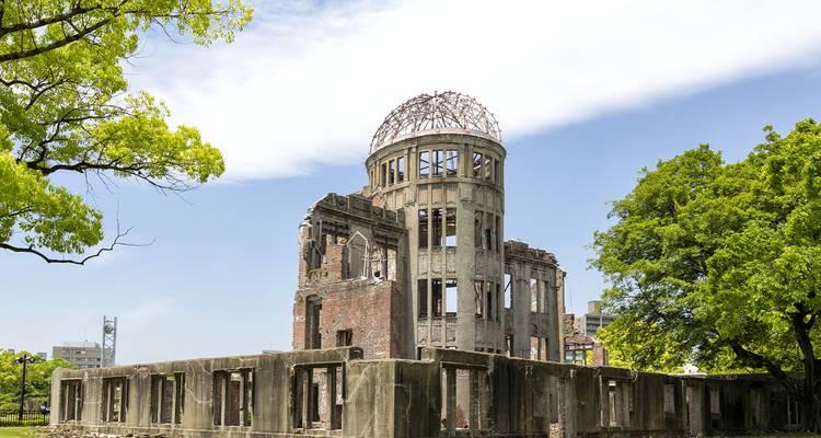 Hiroshima Peace Memorial with trees in the foreground.