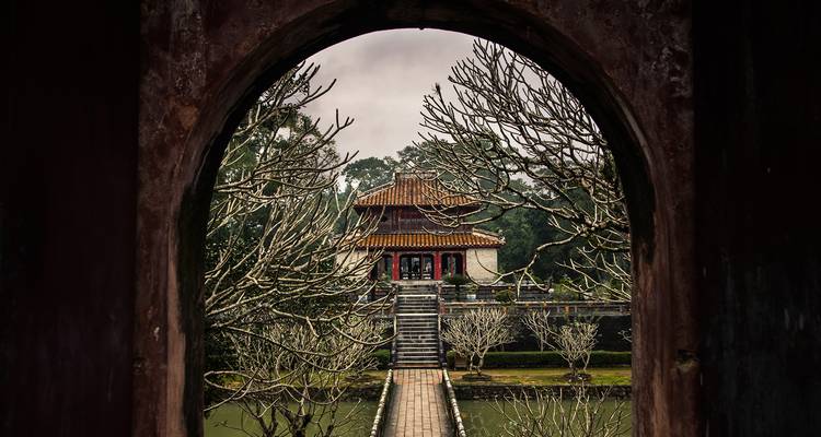 Pagode gerahmt von einem Torbogen mit kahlen Bäumen.