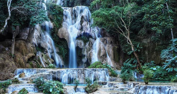 Waterfall cascading over rocks in a lush jungle.