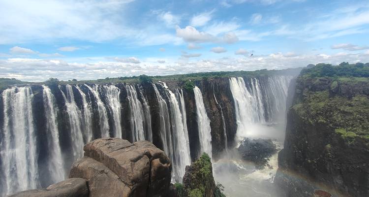 Panoramic view of a large waterfall and surrounding cliffs.