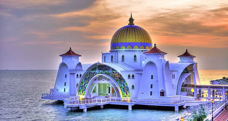 Coucher de soleil coloré derrière la mosquée étincelante du détroit de Malacca perchée au-dessus de la mer.
