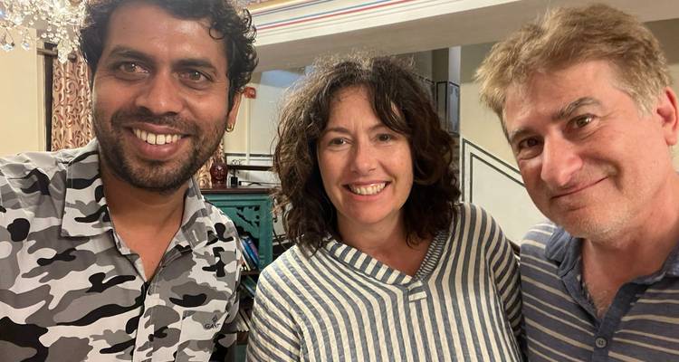 Trois personnes souriantes prenant un selfie à l'intérieur d'un bâtiment.