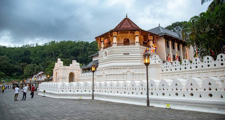 A temple with lit decorations at night with visitors nearby.