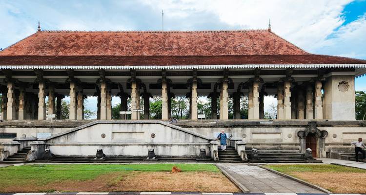 A historical building with columns and red roof in the daytime.