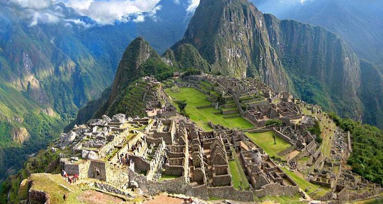 Panoramic view of Machu Picchu set against lush mountains.