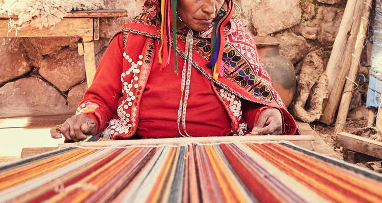 An indigenous person weaving colorful fabric with traditional methods.