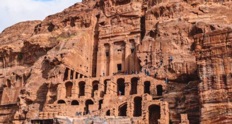 Alte in Fels gehauene Gebäude in Petra mit Touristen.