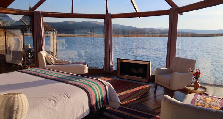 Luxurious room with panoramic lake view from large windows.
