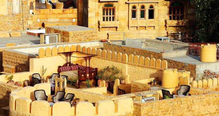 Playa con sombrillas de paja y tumbonas.