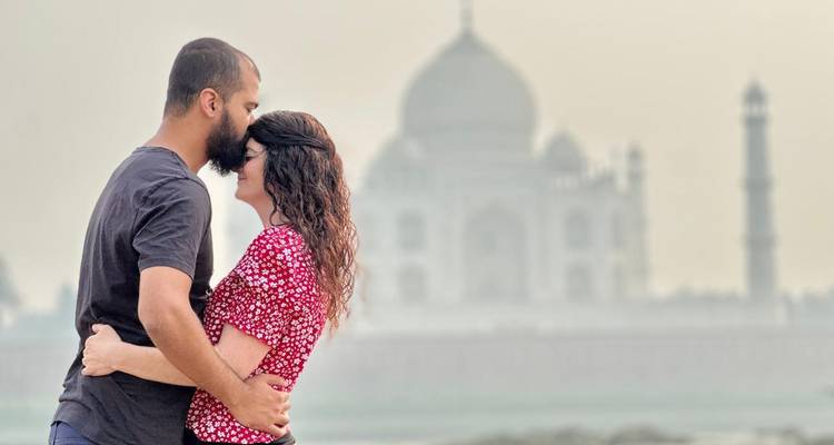 Een stel dat elkaar omhelst met de Taj Mahal op de achtergrond.