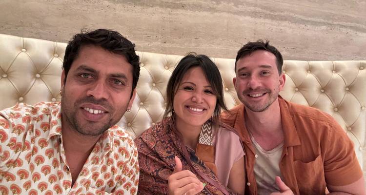 Drie mensen die binnen poseren met decoratieve muren.