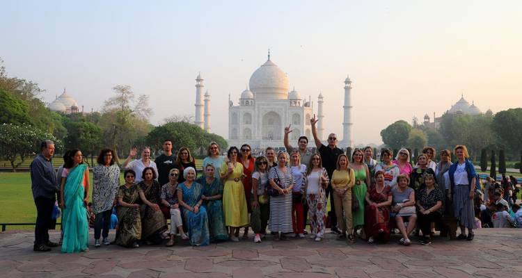 Grote groep mensen die poseren met de Taj Mahal op de achtergrond.