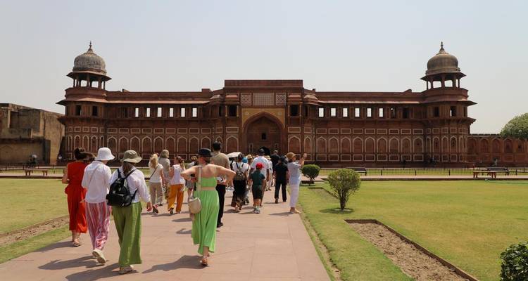 Bezoekers die naar een groot rood fort lopen.