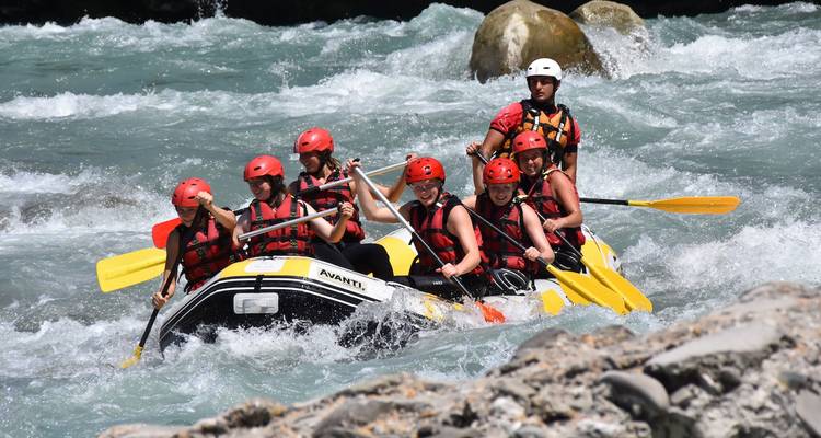 Groupe de personnes faisant du rafting sur une rivière.