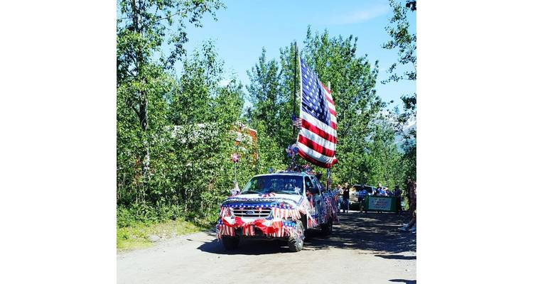 Decorated car in a parade with American flags.