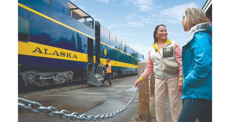 Un groupe de personnes près d'un train de l'Alaska.