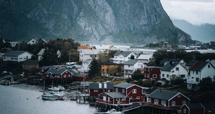 Coastal village with a backdrop of mountains.