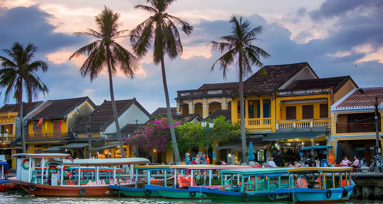Coloridos barcos en el río en Hoi An con palmeras.