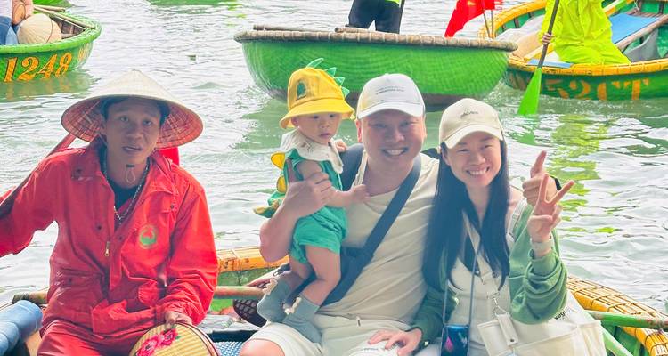 Familie poseert op een mandenboot in een rivieromgeving.