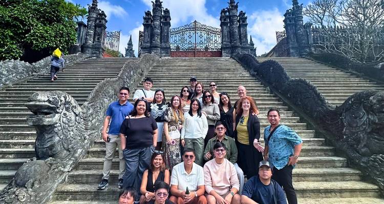 Groep toeristen op de trap van een historische plek met sierlijke poorten.