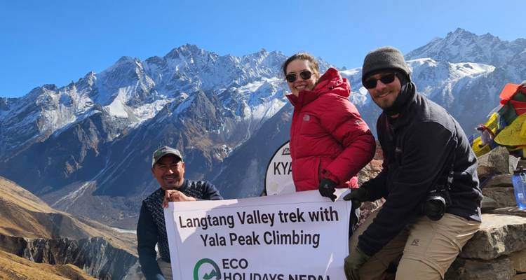Randonneurs avec panneau indicateur de la vallée du Langtang, montagnes en arrière-plan.
