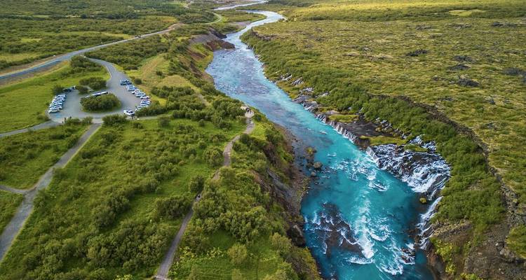 Aerial view of a river cutting through lush green landscape.