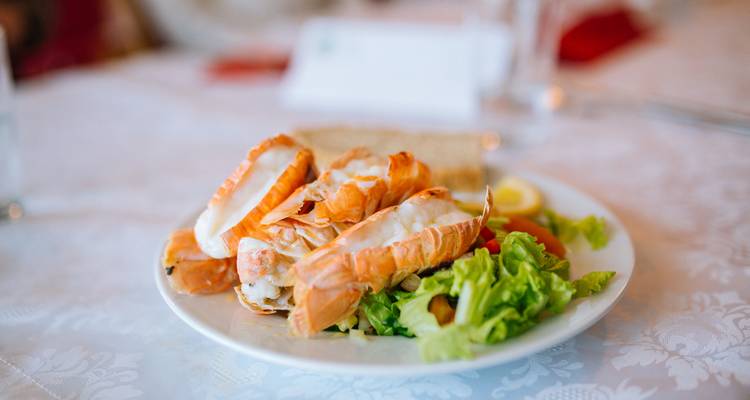 Plate of seafood with salad on a white tablecloth.