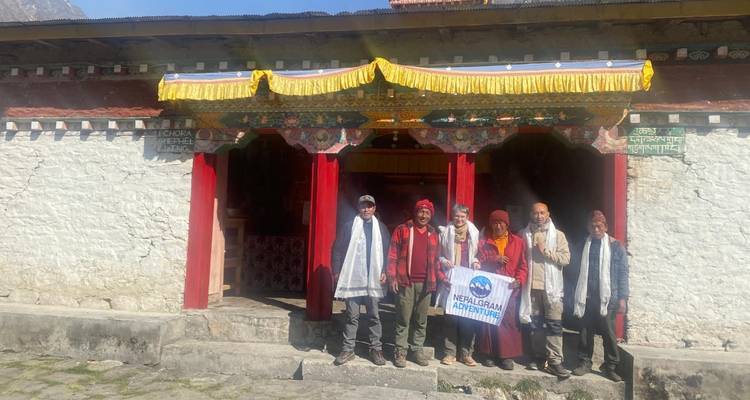 Groupe de personnes en tenue traditionnelle devant un bâtiment religieux.