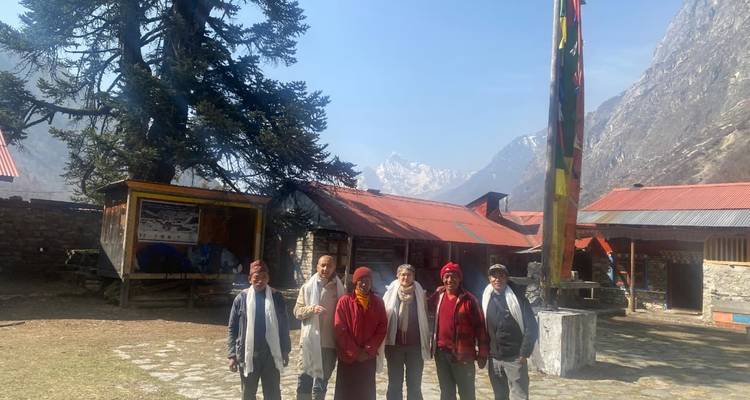 Groupe de personnes posant dehors avec des montagnes en arrière-plan.