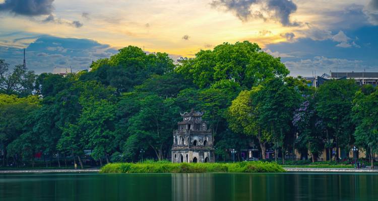 Vista panorámica de una pagoda en un lago al atardecer.