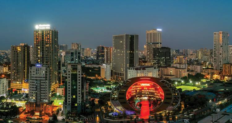 Paisaje urbano con edificios modernos iluminados por la noche.