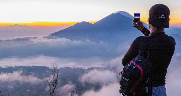 Person taking a photo of mountains at sunrise.