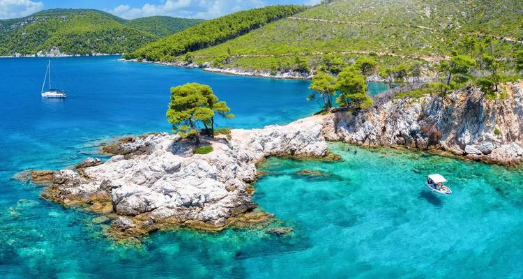 Serene coastline with clear blue waters and lush greenery.