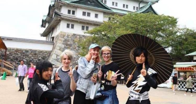 Grupo de personas con disfraces temáticos frente a un edificio histórico.
