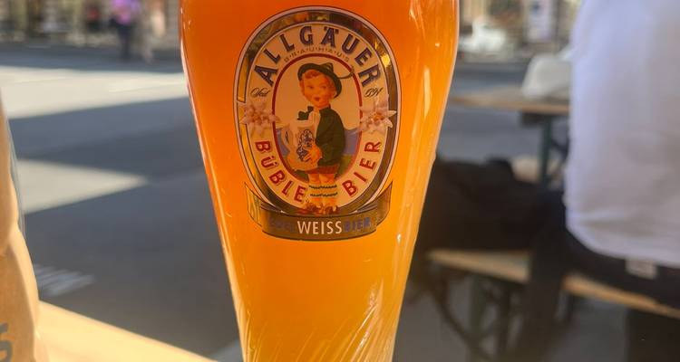 Un grand verre de bière sur une table en extérieur.