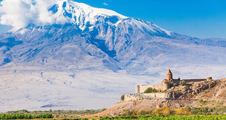 Un monastère historique situé face à une vue sur une grande montagne.