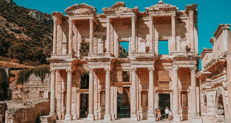 Ruins of the ancient library in Ephesus with tourists nearby.