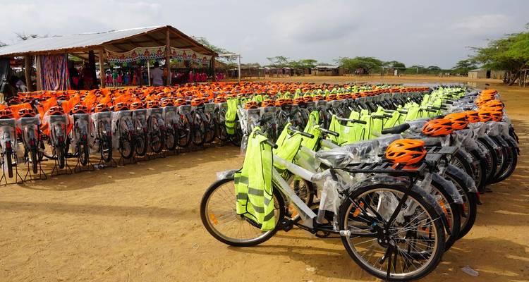 Des rangées de vélos avec des casques orange et des gilets de sécurité.