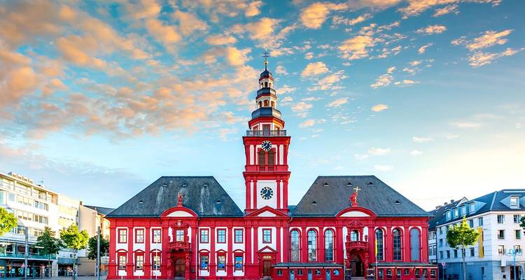 Bâtiment historique coloré avec une tour d'horloge et un ciel dégagé.
