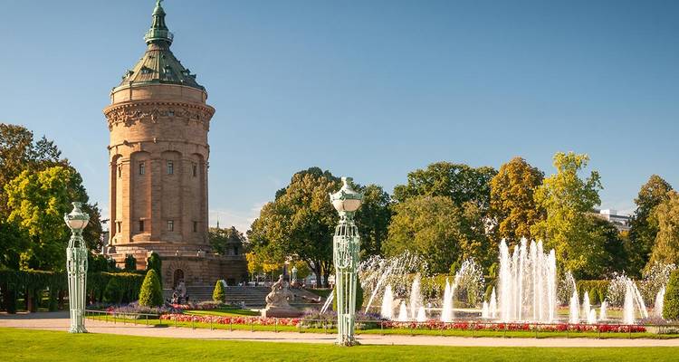 Château d'eau historique encadré par des fontaines et des jardins.