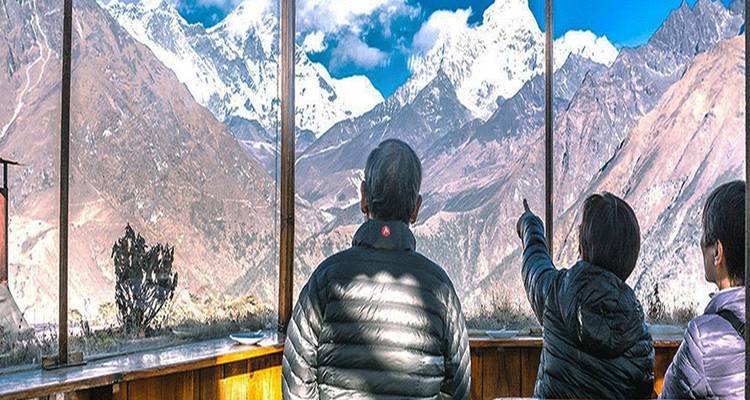 Tres personas disfrutando de una vista de montaña desde el interior.