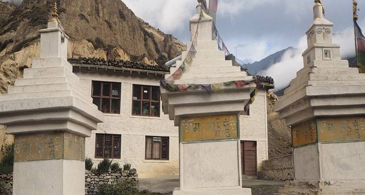 Stupa népalais traditionnel avec des montagnes en arrière-plan.