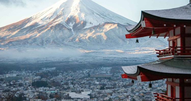 Le mont Fuji enneigé contre un ciel dégagé avec une pagode japonaise traditionnelle.